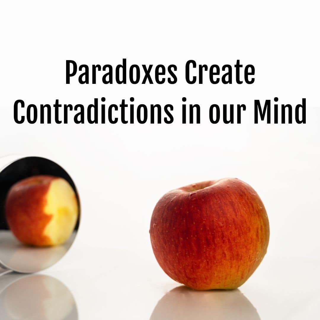 A bitten apple is placed next to a mirror, reflecting a whole apple with no bite. The text "Life Paradoxes Create Contradictions in our Mind" is written above the apple.